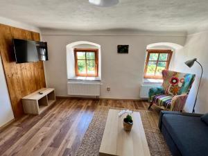 EDER- Penzion & Apartmány في هورني بلانا: غرفة معيشة مع أريكة وطاولة