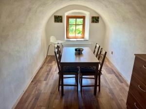 a table and chairs in a room with a window at EDER- Penzion & Apartmány in Horní Planá