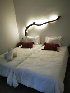 two large white beds sitting next to each other at Niriides Hotel Apartments in Symi