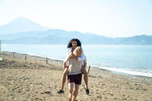 a woman carrying a child on the beach at Lykia Botanika Beach Fun & Club - All Inclusive in Fethiye