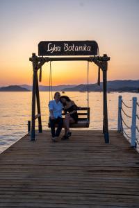two people sitting on a swing on a pier at Lykia Botanika Beach Fun & Club - All Inclusive in Fethiye