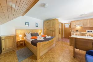 a bedroom with a large bed and a kitchen at Apartments Ukanc in Bohinj