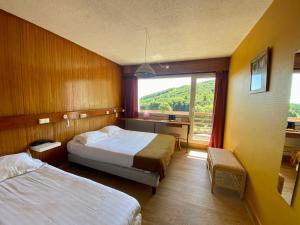 Un pat sau paturi într-o cameră la Hotel Perdrix
