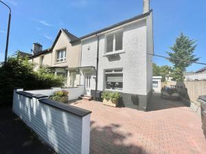 een groot wit huis met een stenen oprit bij Clyde Villa in Glasgow