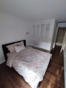 1 dormitorio con 1 cama con edredón de flores en Bel appartement T2 dans résidence à Saint-Raphaël Valescure à 10 minutes de la mer, en Saint-Raphaël