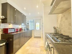 een keuken met roestvrijstalen kasten en een fornuis bij Clyde Villa in Glasgow