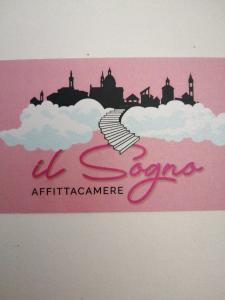 a pink sign with a city in the clouds at Il Sogno in Foligno