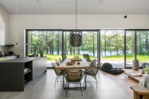 a kitchen and dining room with a table and chairs at The Lake - Waterfront Villas Retreat in Mindūnai
