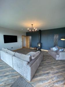 a living room with a couch and a flat screen tv at Three-winds-guesthouse in South Crosland