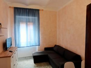 a living room with a black couch and a window at Santo Stefano beach in Porto Santo Stefano