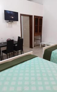 um quarto com uma mesa e cadeiras e uma televisão em Villa Colonial Suite 5, Familiar Plus. em Río San Juan