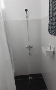 a shower in a white bathroom with a sink at Villa Colonial Suite 5, Familiar Plus. in Río San Juan