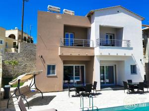 a villa with a swimming pool in front of a house at Golden Days villas in Sívas