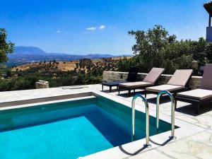 a swimming pool with chairs and a view of the canyon at Golden Days villas in Sívas
