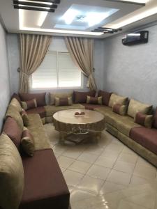 a living room with a couch and a table at Hay salam réservé aux familles in Agadir