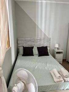 1 dormitorio pequeño con 1 cama y ventilador en Casa Fè, en Fregene