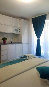 - une chambre avec un grand lit et un rideau bleu dans l'établissement Garsoniera Camy, à Saturn