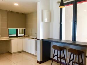 a kitchen with a blue counter and two stools at D Wharf Port Dickson Private Condo Waterfront in Port Dickson