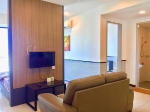 a living room with a couch and a flat screen tv at D Wharf Port Dickson Private Condo Waterfront in Port Dickson