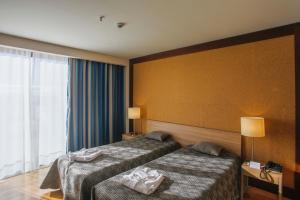Postel nebo postele na pokoji v ubytování Antillia Hotel