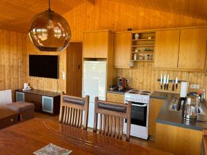 eine Küche mit einem weißen Kühlschrank und Holzschränken in der Unterkunft Aurora Cottage on the Golden Circle in Selfoss