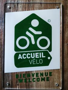 a sign on a wooden wall with a sign for a bicycle welcome at Le Clos de La Chardonnière in Saulce-sur-Rhône