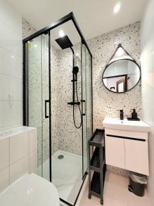 a bathroom with a shower and a sink and a mirror at Apartament 21 in Gdynia