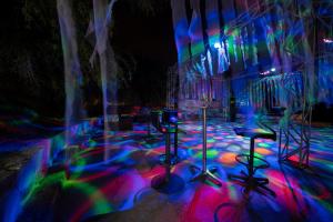 a room with colorful lights and tables and chairs at Lykia Botanika Beach Fun & Club - All Inclusive in Fethiye
