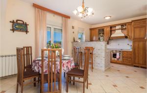 a kitchen with a table and chairs and a fireplace at Amazing Apartment In Viskovo With Wifi in Viskovo