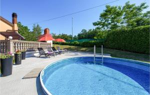 a swimming pool in a yard with chairs and umbrellas at Amazing Apartment In Viskovo With Wifi in Viskovo