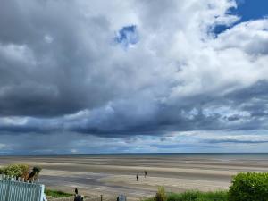 widok na plażę z ludźmi chodzącymi po piasku w obiekcie Bovinda Cottage - By the Beach, Bettystown w mieście Bettystown