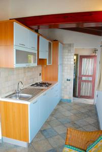 奧提奧洛港的住宿－Bilo Vista Mare Agrustos，厨房配有水槽和炉灶 顶部烤箱