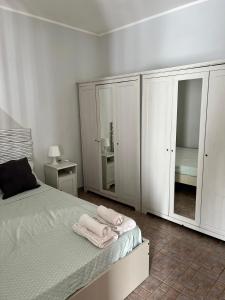 1 dormitorio con armarios blancos y toallas en una cama en Casa Fè, en Fregene
