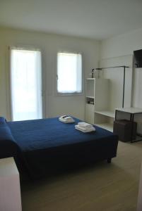 1 dormitorio con 1 cama azul y 2 toallas en B&B da Rosy en Lazise