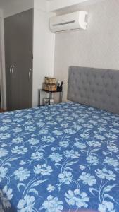 a bedroom with a bed with a blue and white blanket at Apartamento Barra Paraíso Tropical in Rio de Janeiro