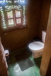 a bathroom with a toilet and a window at Sítio Monte Alegre in Ibicoara