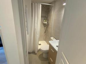 a bathroom with a toilet and a white shower curtain at Home Sweet Home Batignolles in Paris