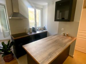 a kitchen with a wooden counter top and a sink at Home Sweet Home Batignolles in Paris