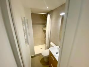 La petite salle de bains est pourvue de toilettes et d'un lavabo. dans l'établissement Home Sweet Home Batignolles, à Paris