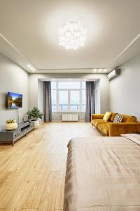 a large living room with a couch and a tv at Botanic Towers in Kyiv