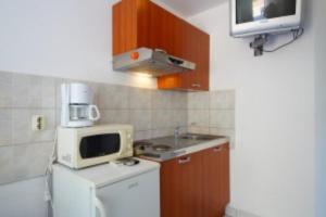 a small kitchen with a microwave and a sink at Apartment 4 in Orebić