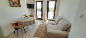 - un salon avec un canapé et une table dans l'établissement Apartmani Dragovic, à Brodarica