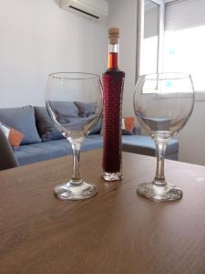 スプリトにあるGreat apartment, free parking in the garage, Žnjanのワイングラス2杯、テーブルの上にボトル1本