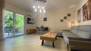 salon z kanapą i stołem w obiekcie Elena apartment chalkidiki w mieście Kallithea