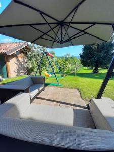 a playground with an umbrella and a swing at San Marcello Residence in Feltre