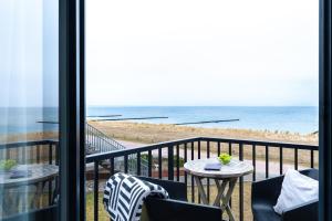 a balcony with a view of the beach at Aparthotel Ostseeperle Glowe - schön gestrandet in Glowe