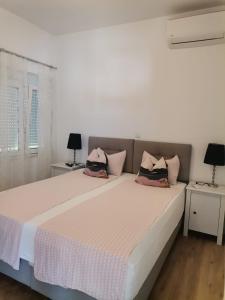 um quarto com uma grande cama branca e duas mesas em Apartment Nino em Zadar