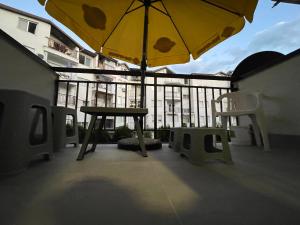 a table and a yellow umbrella on a balcony at DARTAD APARTMENT in Ohrid
