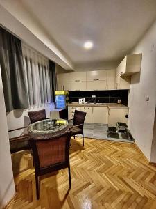 a living room with a table and chairs and a kitchen at DARTAD APARTMENT in Ohrid