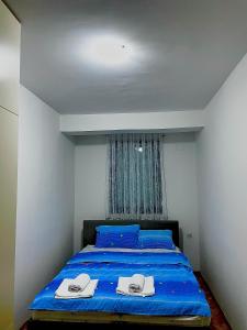 a bedroom with a blue bed with two towels on it at DARTAD APARTMENT in Ohrid